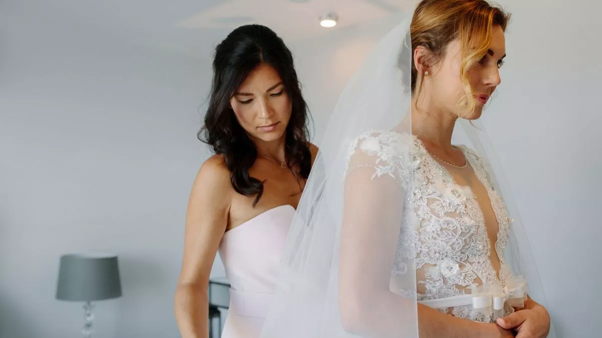 1 Bridesmaid helping bride to put on a veil